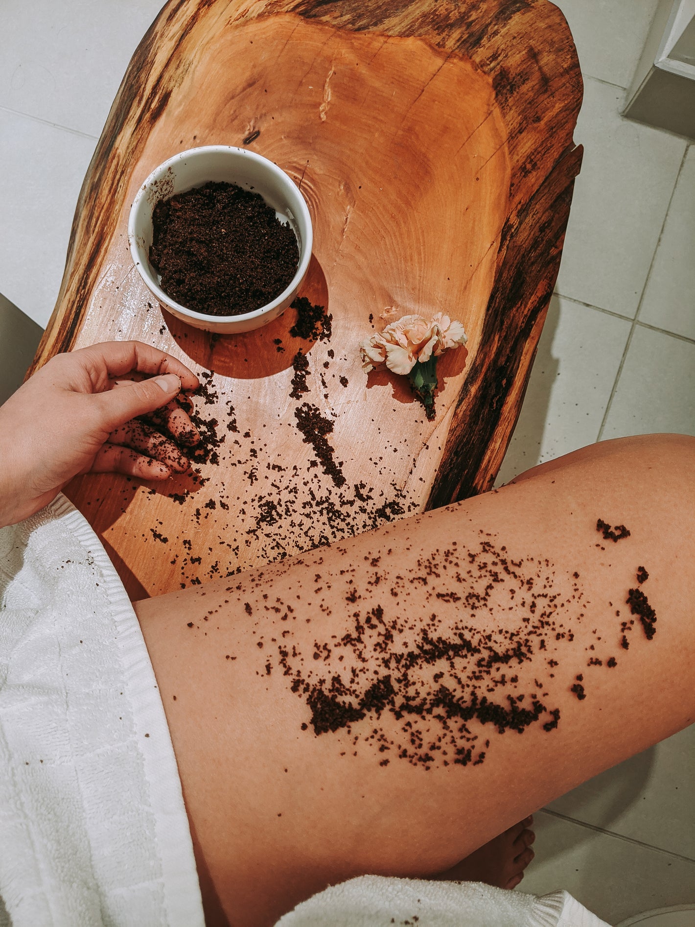 A leg with coffee scrub and a white towel